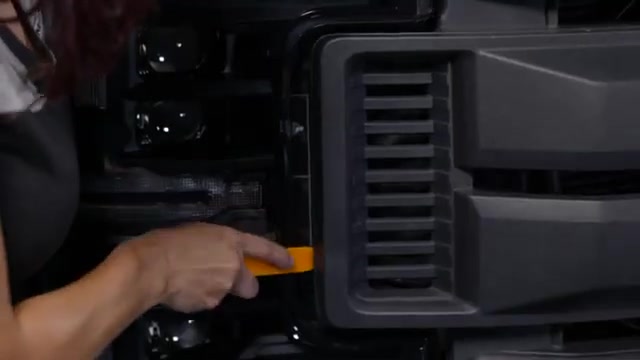 Removing the 10mm bolts securing the Ford Super Duty grille